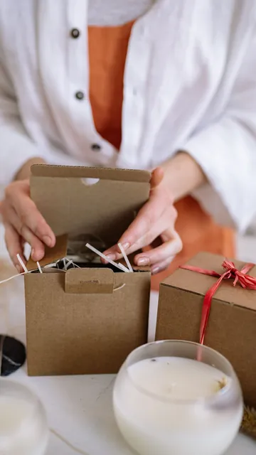 Sample ad, vertical: hands opening a gift box beside a white candle.